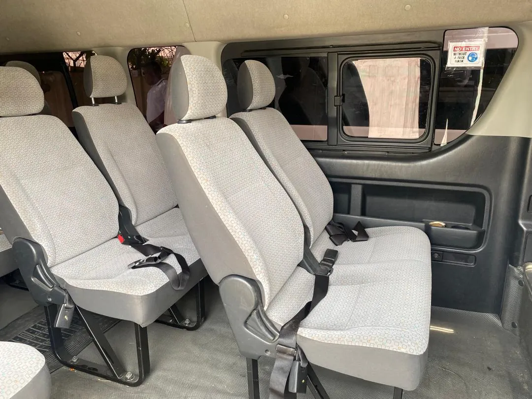 Toyota Hiace interior with grey patterned cloth passenger seats and seat belts